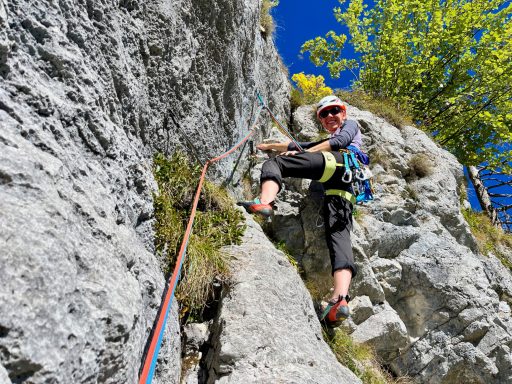 Kletterer sichert sich an einer Felswand mit Seil und Bewegungen in die Höhe.