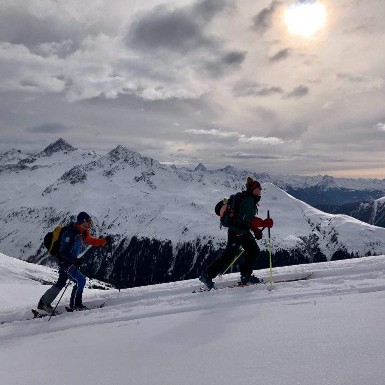 Ein Skifahrer auf einer schneebedeckten Berglandschaft mit Felsen.