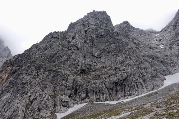 Felsige Berglandschaft mit grauen Felsen und bewölktem Himmel.