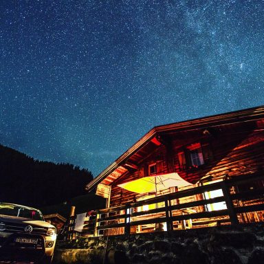 Skitouren Camp Rofan Ferienhaus bei Nacht unter einem sternenübersäten Himmel.
