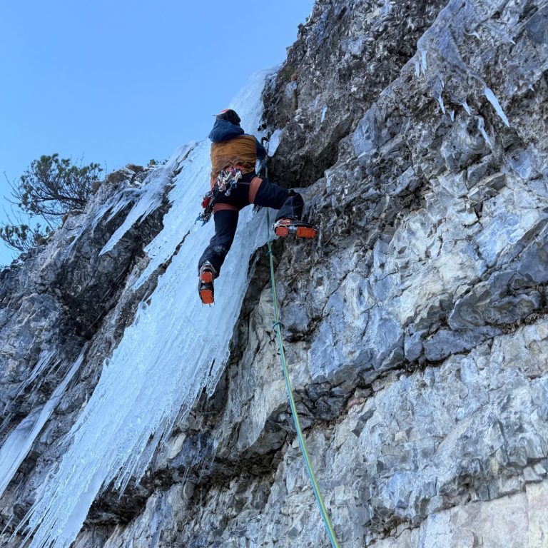 Kletterer erkundet eine gefrorene Felswand mit Eisklettern.