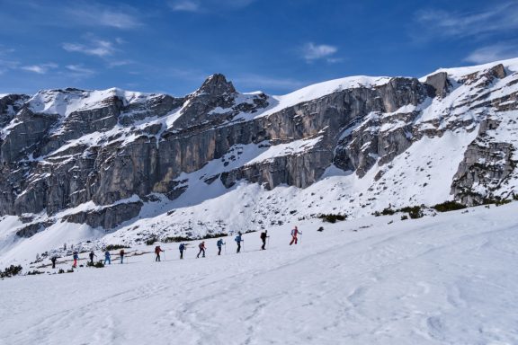 Skitouren Camp Rofan Skiende Menschen vor majestätischen, schneebedeckten Bergen.