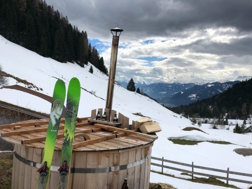 Skitouren Camp Rofan Skier's equipment auf einem Holzfass in verschneiter Berglandschaft.