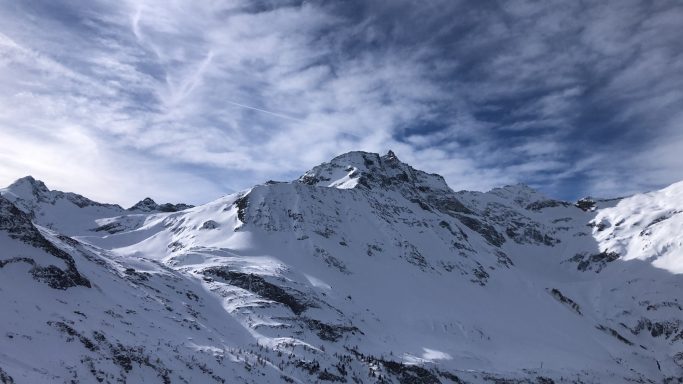 Schneebedeckte Berge unter einem bewölkten Himmel.